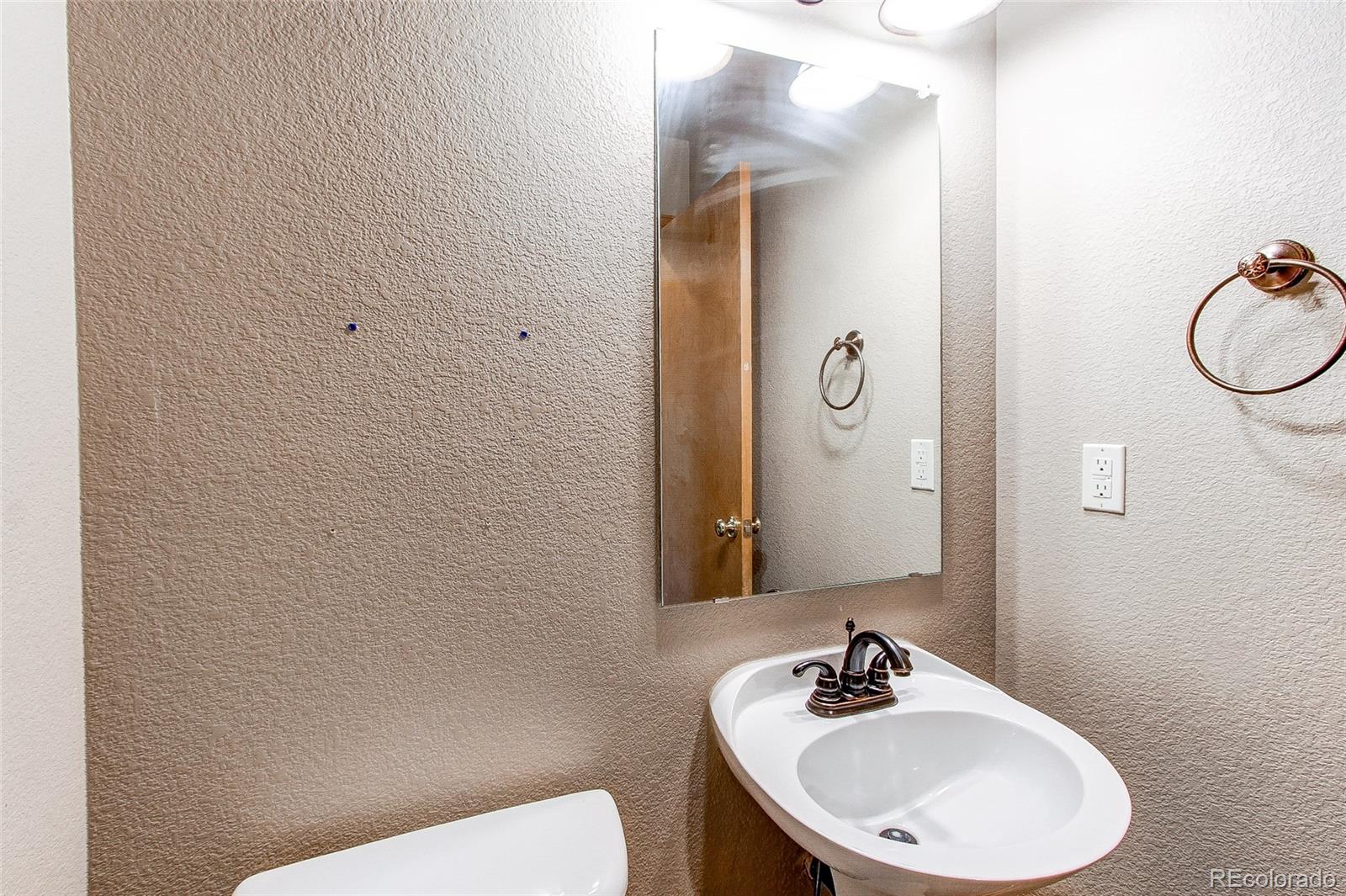 9776 Gatesbury Circle Highlands Ranch, CO 80126 - Photo 9 of 24 a bathroom with a sink a toilet and mirror
