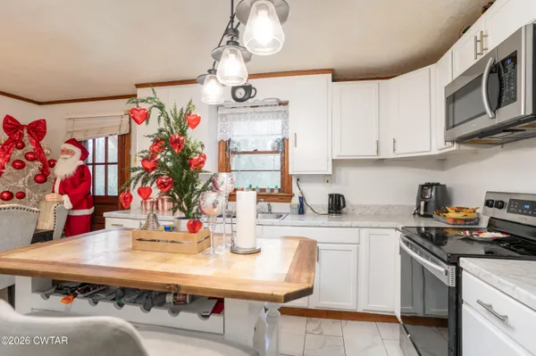 a kitchen with kitchen island stainless steel appliances a sink and cabinets
