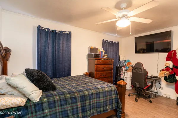 a bedroom with a bed a flat screen tv and dresser