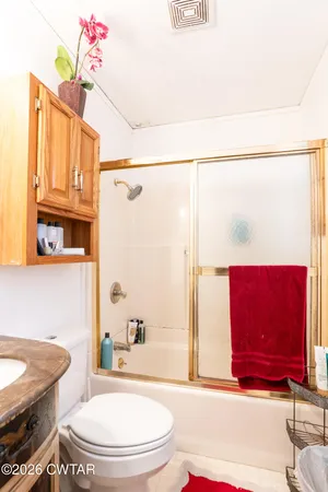 a bathroom with a sink mirror and toilet