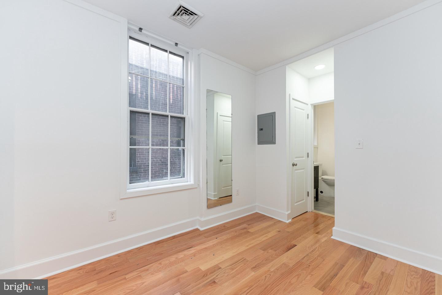 2118 Spruce Street, Unit 2R Philadelphia, PA 19103 - Photo 14 of 25 an empty room with wooden floor and windows