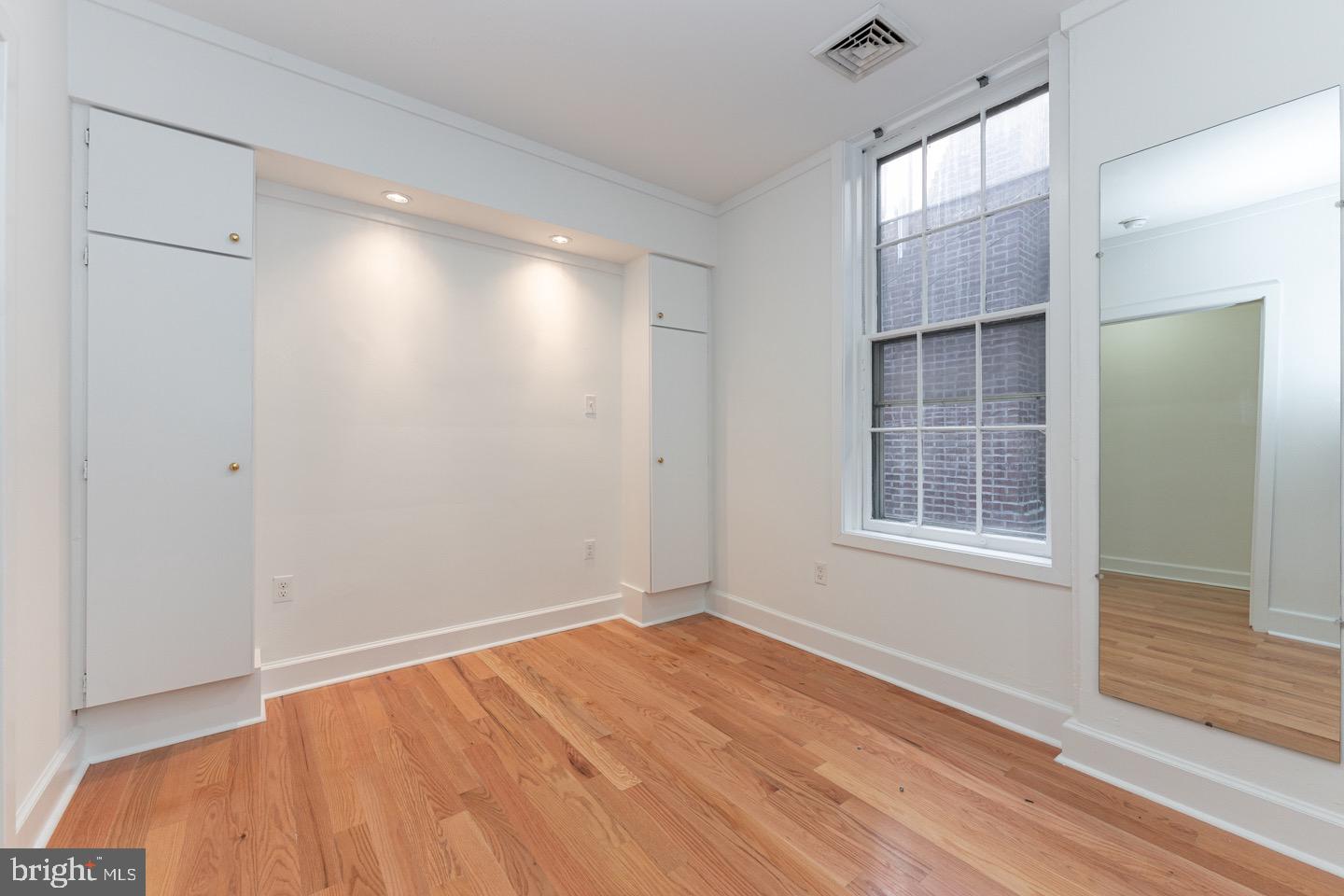 2118 Spruce Street, Unit 2R Philadelphia, PA 19103 - Photo 17 of 25 an empty room with wooden floor and windows
