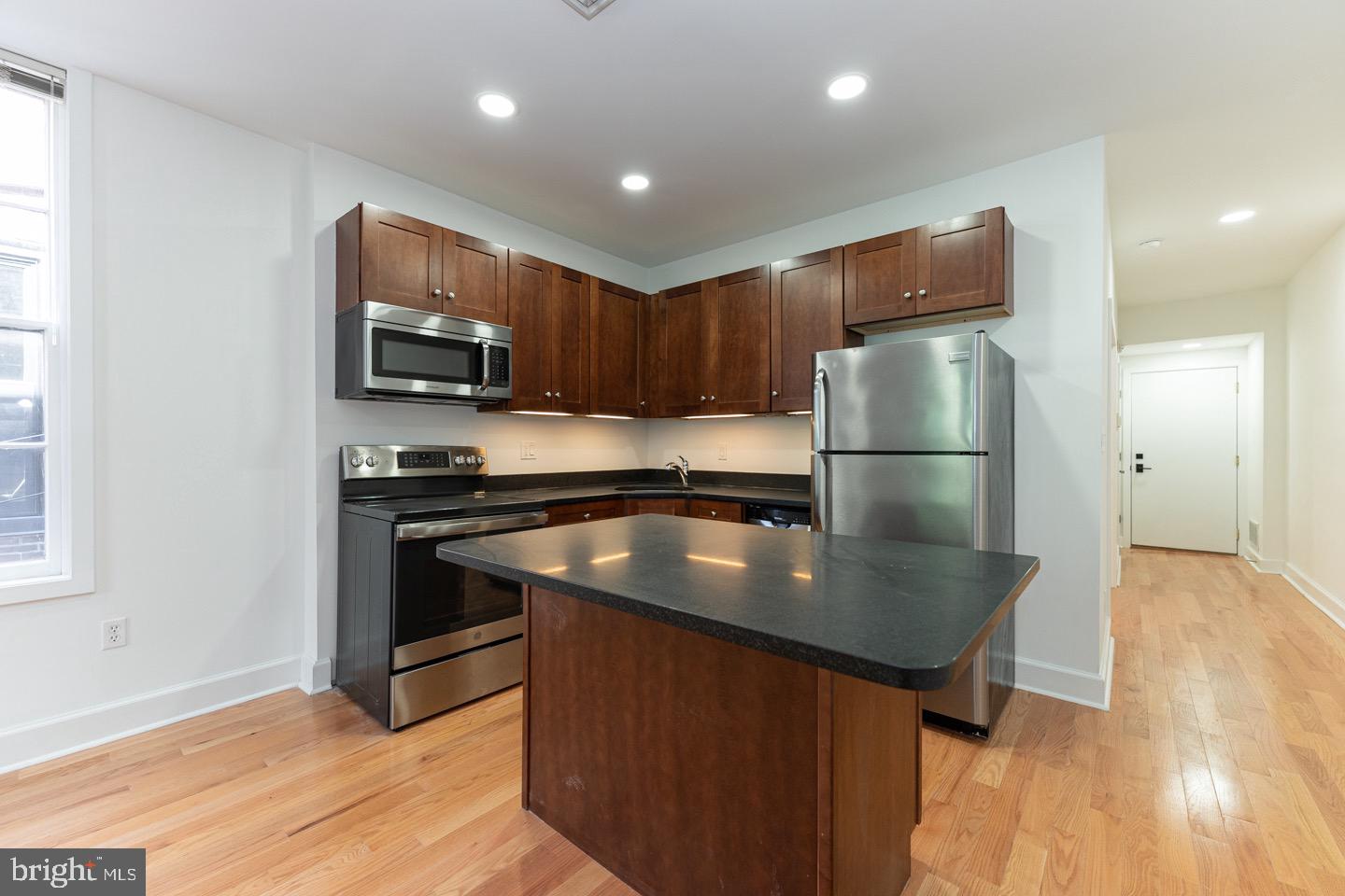 2118 Spruce Street, Unit 2R Philadelphia, PA 19103 - Photo 2 of 25 a kitchen with kitchen island a refrigerator stove and microwave