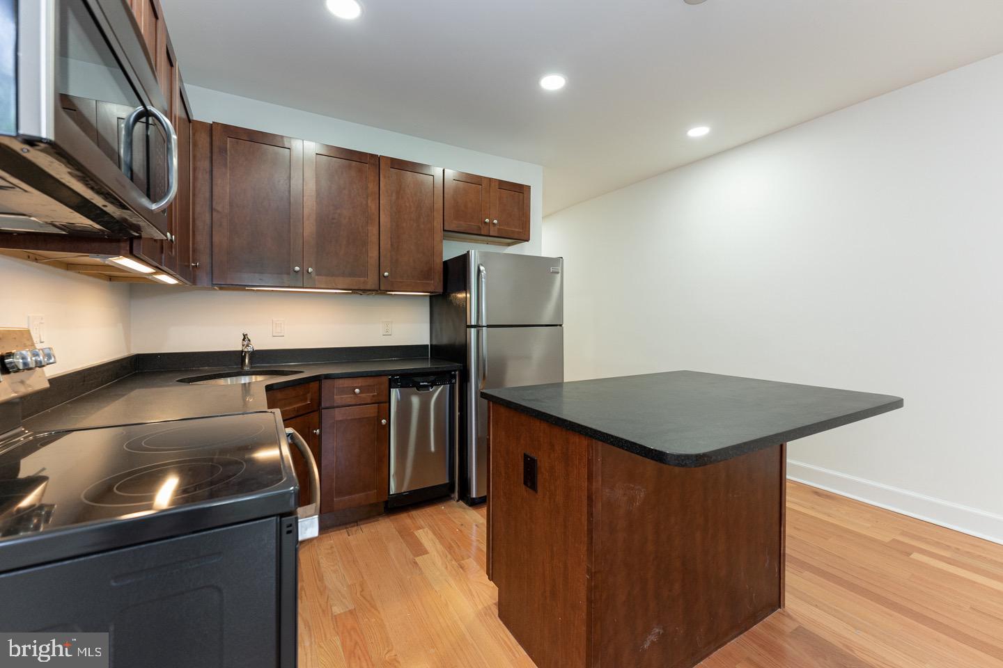 2118 Spruce Street, Unit 2R Philadelphia, PA 19103 - Photo 3 of 25 a kitchen with stainless steel appliances granite countertop a sink a stove microwave and cabinets