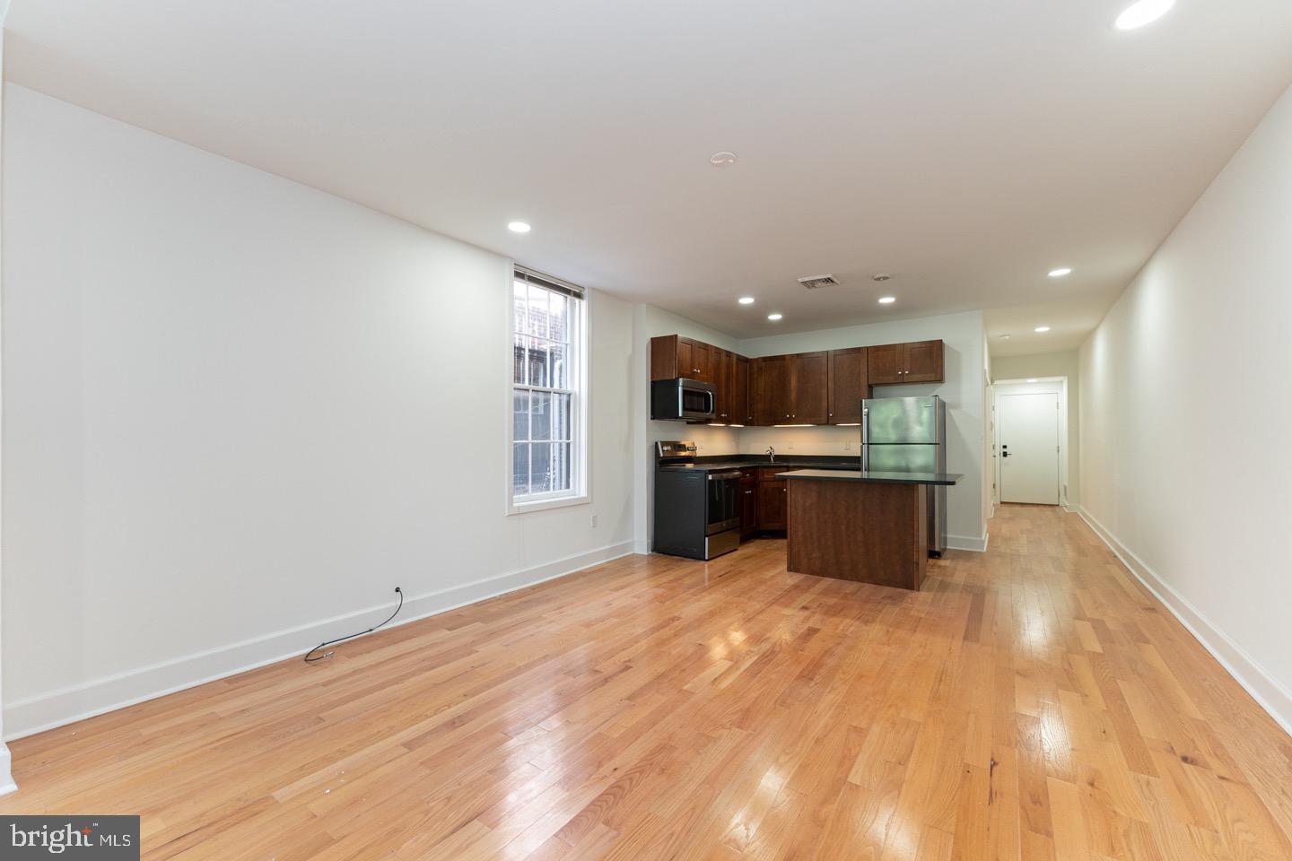2118 Spruce Street, Unit 2R Philadelphia, PA 19103 - Photo 7 of 25 a large kitchen with kitchen island a sink stainless steel appliances and cabinets