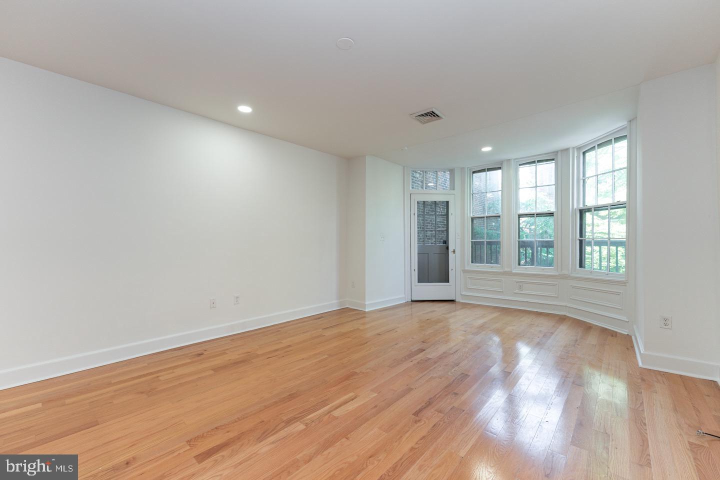 2118 Spruce Street, Unit 2R Philadelphia, PA 19103 - Photo 9 of 25 a view of an empty room with wooden floor and a window