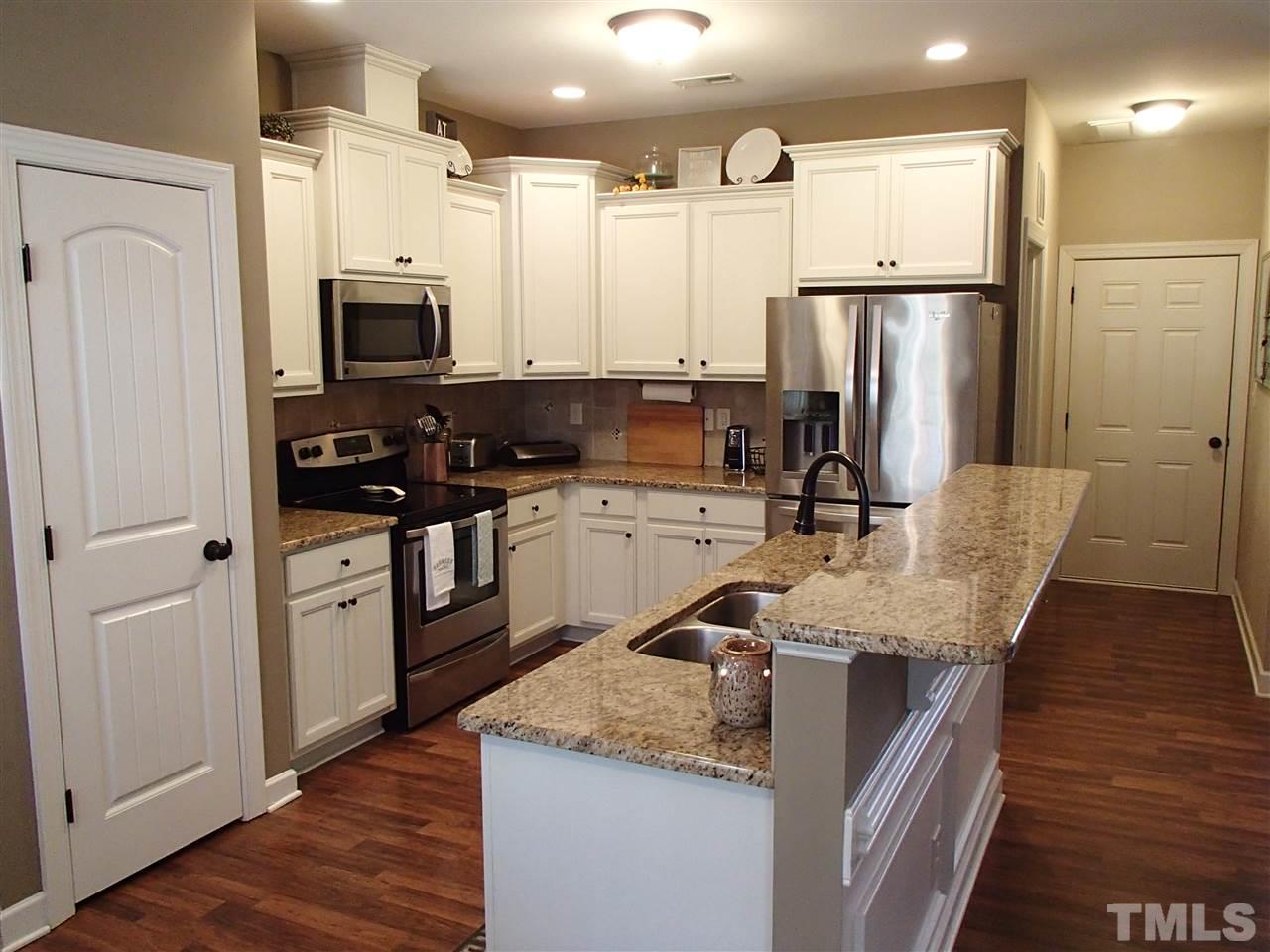 2183 Matthews Road Clayton, NC 27520 - Photo 15 of 25 This beautiful kitchen features recess lighting, pantry, granite countertops, custom tile backsplash, almost new SS appliances, updated fixtures and an island with a raised bar.