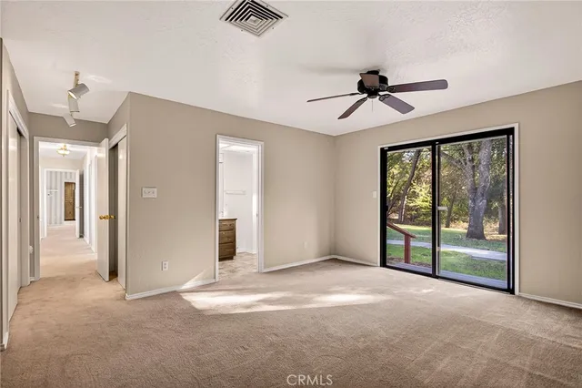 an empty room with ceiling fan and window