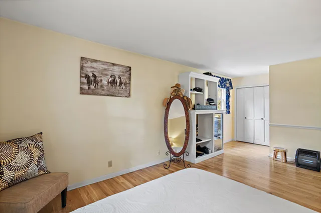 a bedroom with a bed and wooden floor