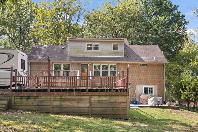 a view of a house with large trees and a small barn