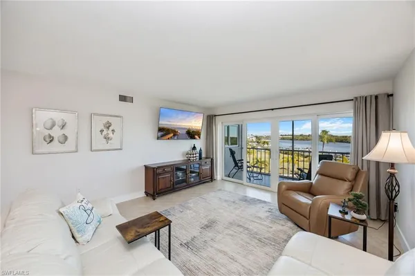 a living room with furniture and a large window with balcony view