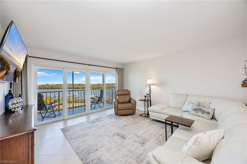 309 Goodlette-Frank Road, Unit A406 Naples, FL 34102 - Photo 3 of 14 a living room with furniture and a floor to ceiling window