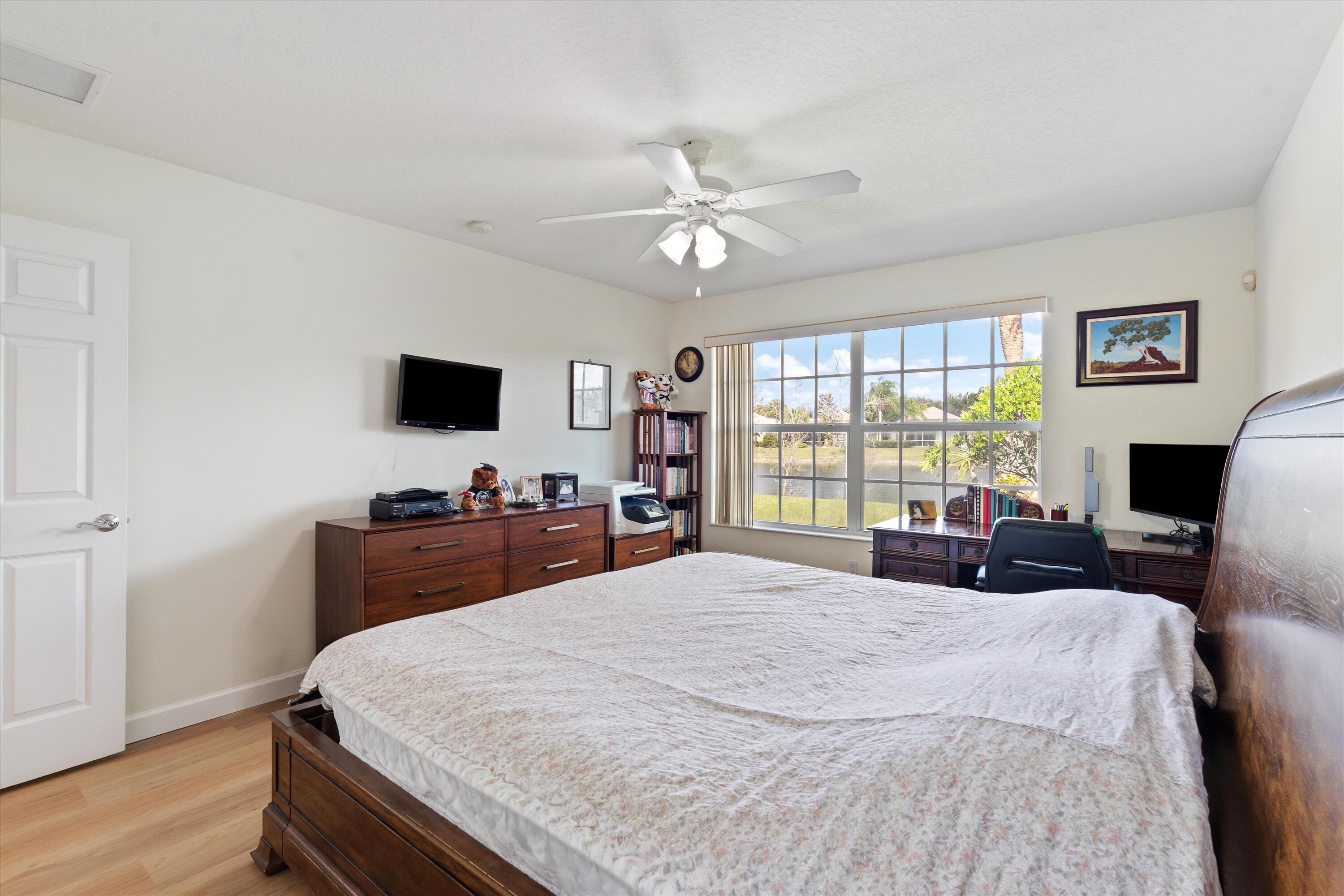 8255 Quito Place Wellington, FL 33414 - Photo 14 of 23 a bedroom with a bed and a flat screen tv