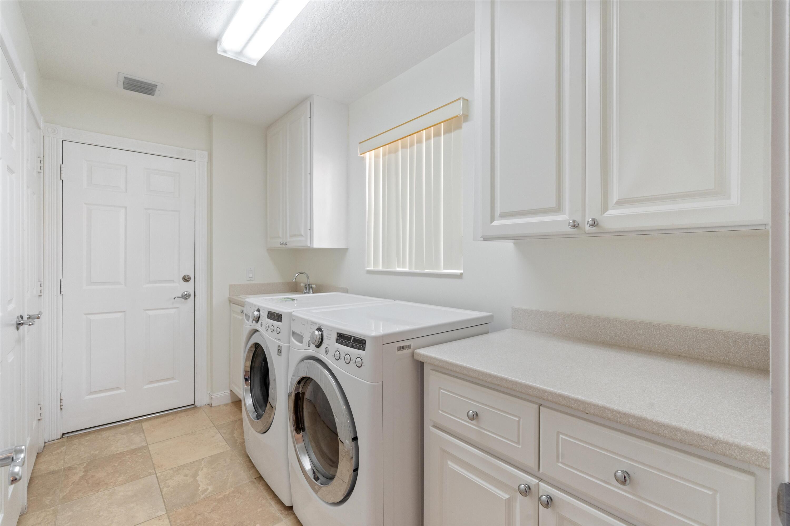 8255 Quito Place Wellington, FL 33414 - Photo 19 of 23 a utility room with dryer and washer