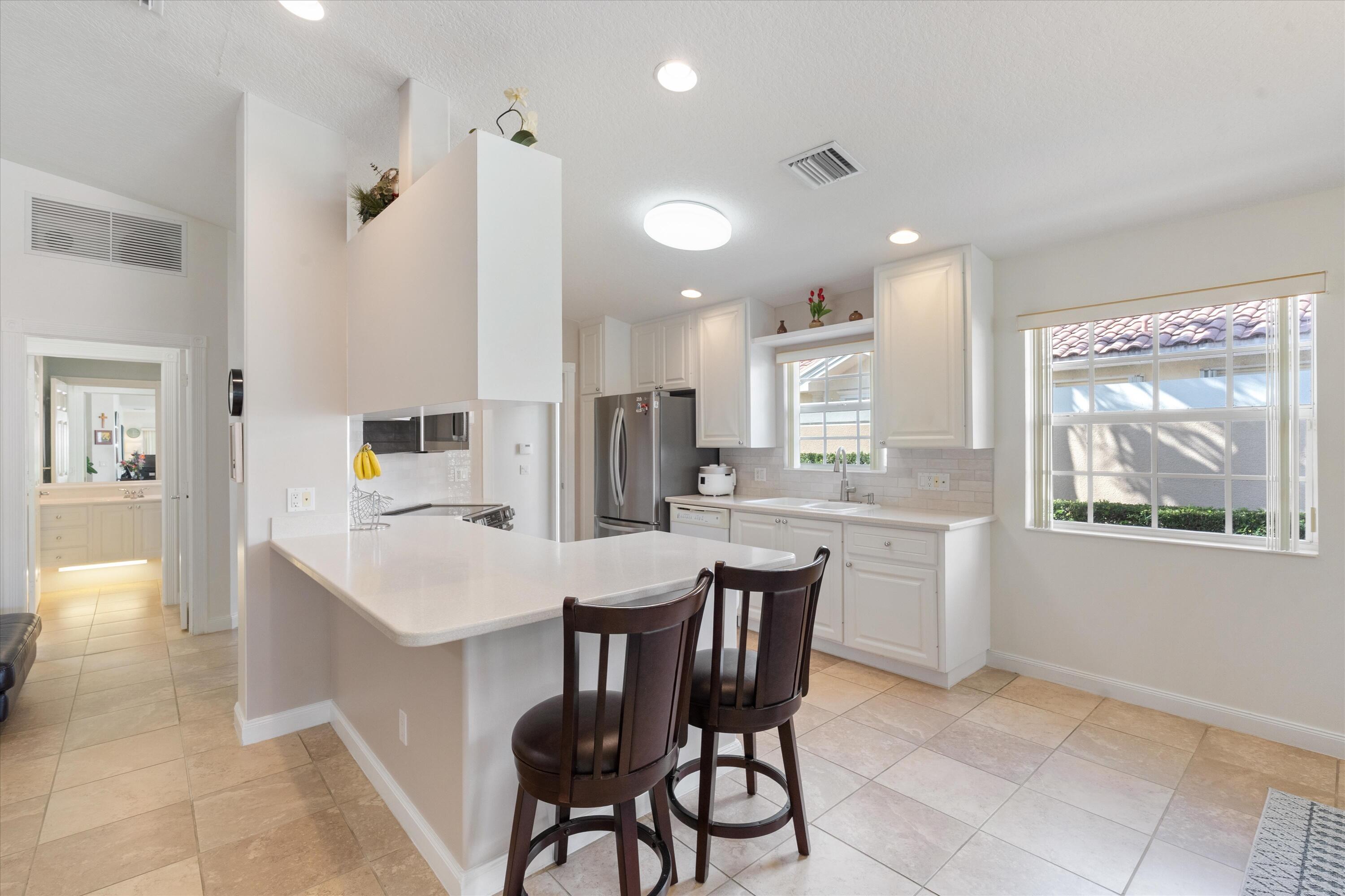 8255 Quito Place Wellington, FL 33414 - Photo 6 of 23 a kitchen with stainless steel appliances kitchen island granite countertop a sink and cabinets