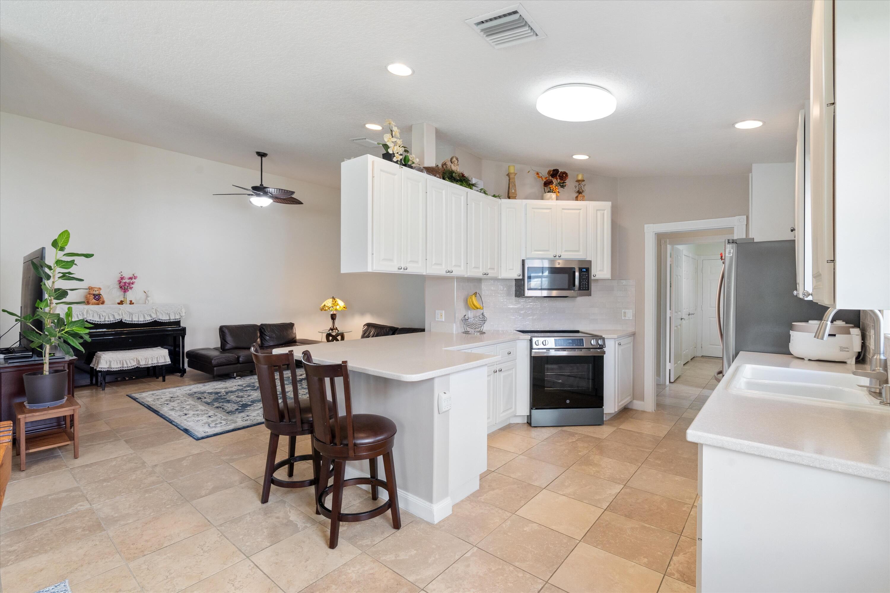 8255 Quito Place Wellington, FL 33414 - Photo 7 of 23 a kitchen with refrigerator and chairs