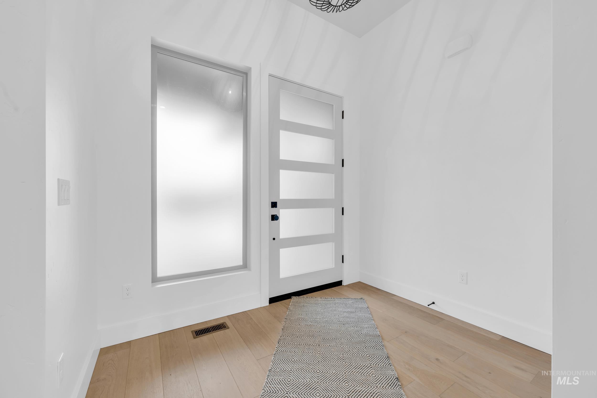 4447 East Copper Point Drive Meridian, ID 83642 - Photo 4 of 41 Entryway featuring baseboards and light wood finished floors