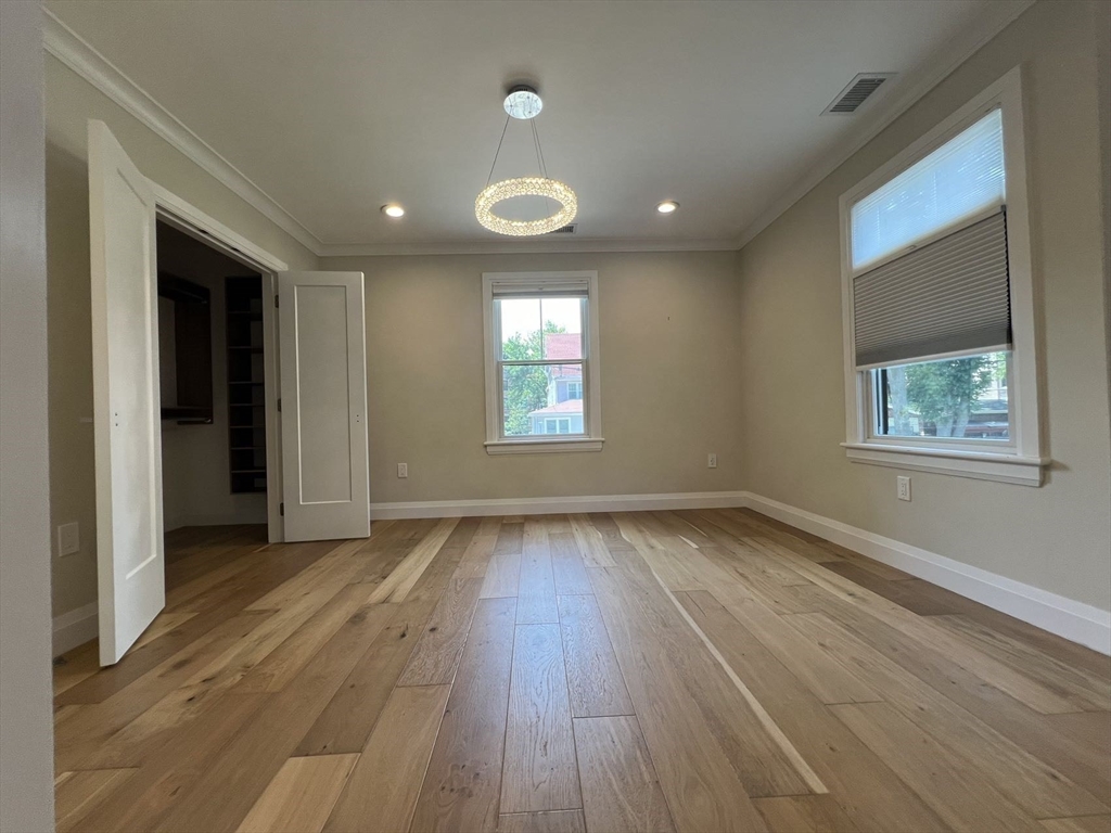 23 Winslow Road, Unit 1 Brookline, MA 02446 - Photo 12 of 27 an empty room with wooden floor and windows