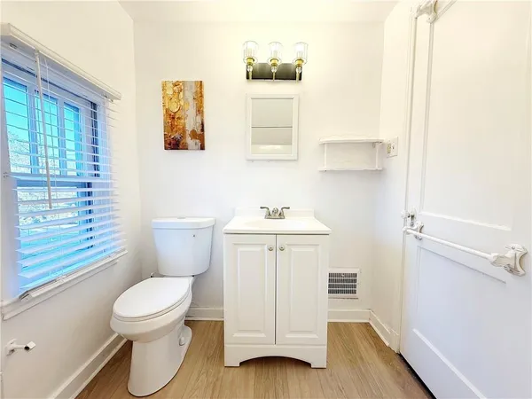 a bathroom with a toilet a sink and a window