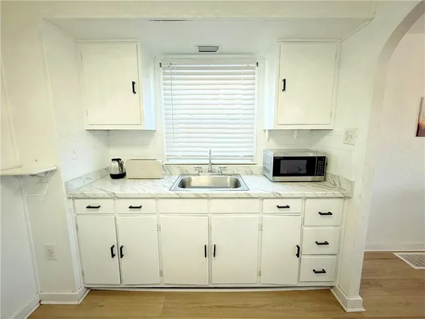 a kitchen with cabinets appliances a sink and a window