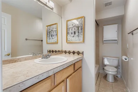 a bathroom with a granite countertop sink toilet and a mirror