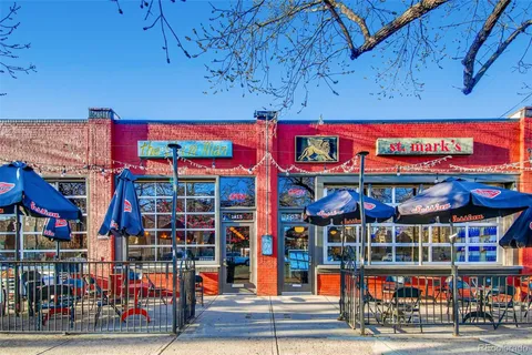 a view of a cafe with a table and chairs under an umbrella