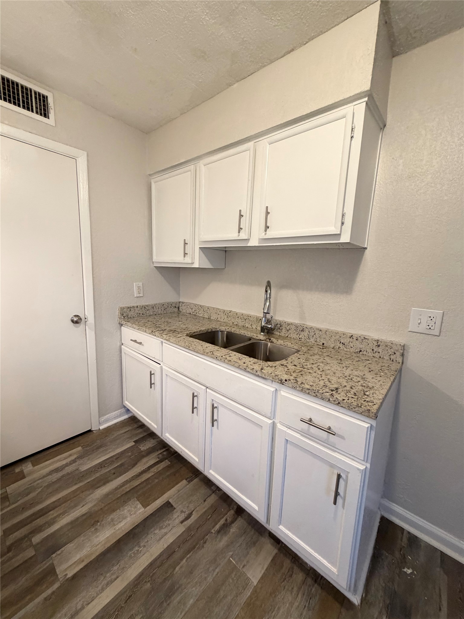 1614 Vauthier Street, Unit 11 La Marque, TX 77568 - Photo 6 of 16 a kitchen with granite countertop white cabinets and white appliances