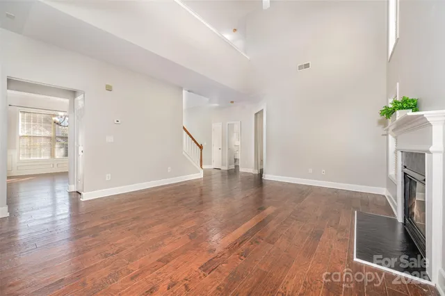 an empty room with wooden floor and a fireplace