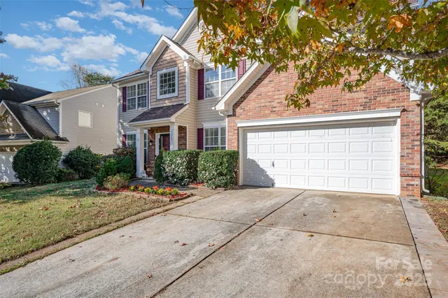 a front view of a house with a yard and potted plants