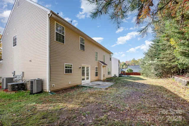 a view of a house with backyard and trees