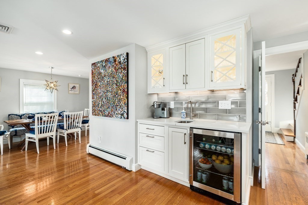 37 Tufts Road Winchester, MA 01890 - Photo 11 of 39 a kitchen with stainless steel appliances granite countertop a stove top oven a dining table and white cabinets with wooden floor