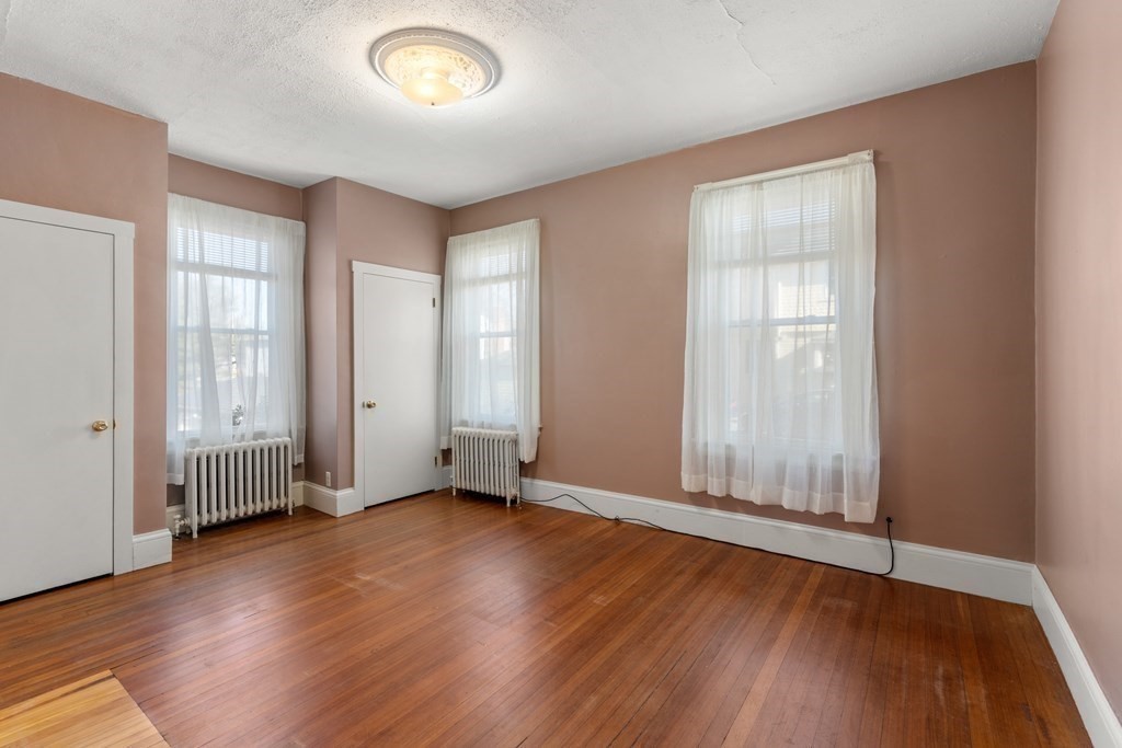 11 Jenison Street Newton, MA 02460 - Photo 32 of 42 an empty room with wooden floor and windows
