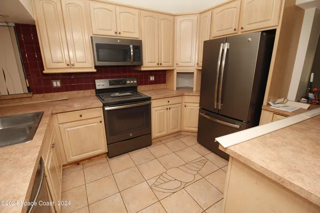 a kitchen with stainless steel appliances a stove a microwave and a sink
