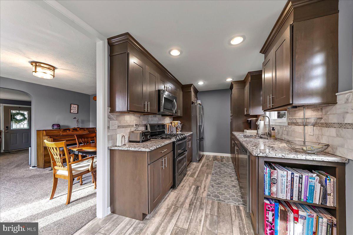 311 Laurel Road Sharon Hill, PA 19079 - Photo 12 of 28 a kitchen with stainless steel appliances granite countertop lots of counter top space and wooden floor