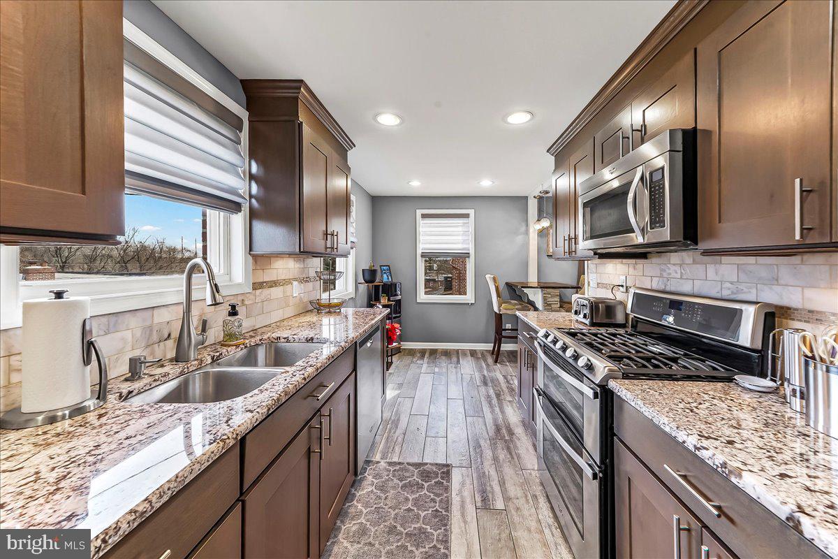 311 Laurel Road Sharon Hill, PA 19079 - Photo 14 of 28 a kitchen with stainless steel appliances granite countertop sink stove top oven and cabinets