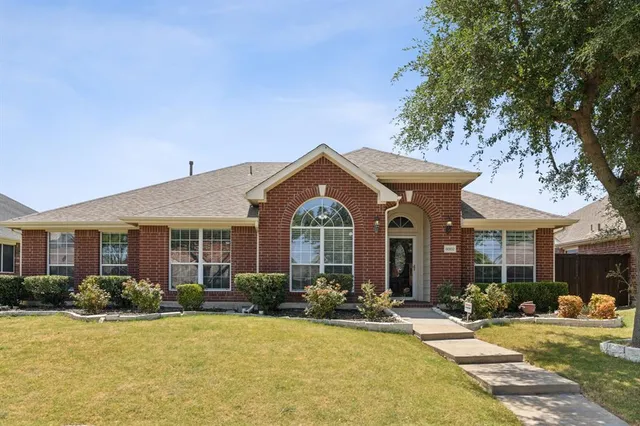 a front view of a house with yard and green space