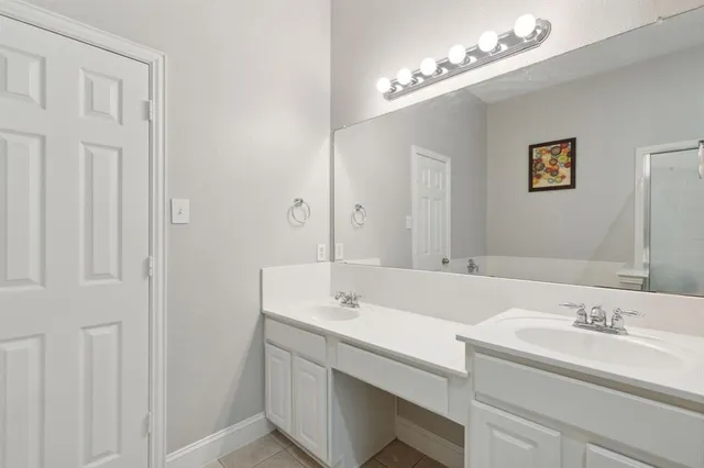 an empty room with wooden floor chandelier and windows