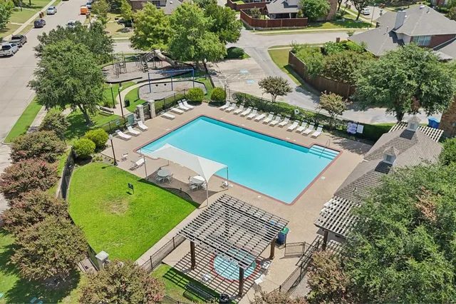 an aerial view of a backyard with swimming pool and outdoor seating
