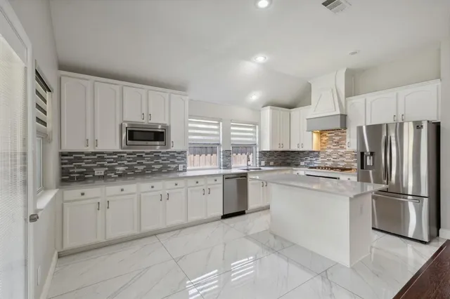 a kitchen with granite countertop cabinets stainless steel appliances and a counter space