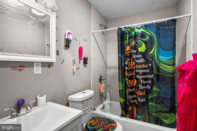 a bathroom with a sink a toilet and a shower curtain