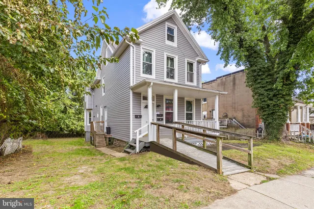 a view of house with a yard and sitting area