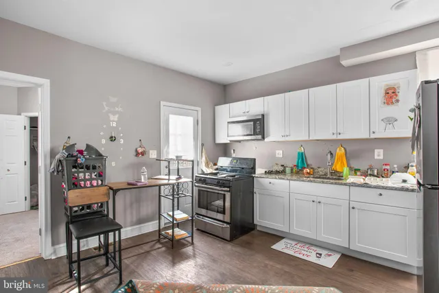 a kitchen with white cabinets and appliances