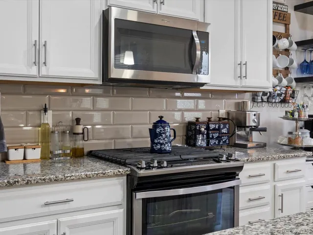 a view of storage and utility room with refrigerator and cabinets