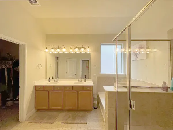 a bathroom with a sink mirror and a shower