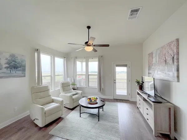 a living room with furniture a chandelier and a flat screen tv