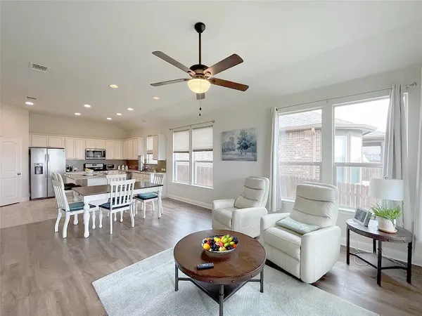 a living room with furniture a rug potted plant and a large window