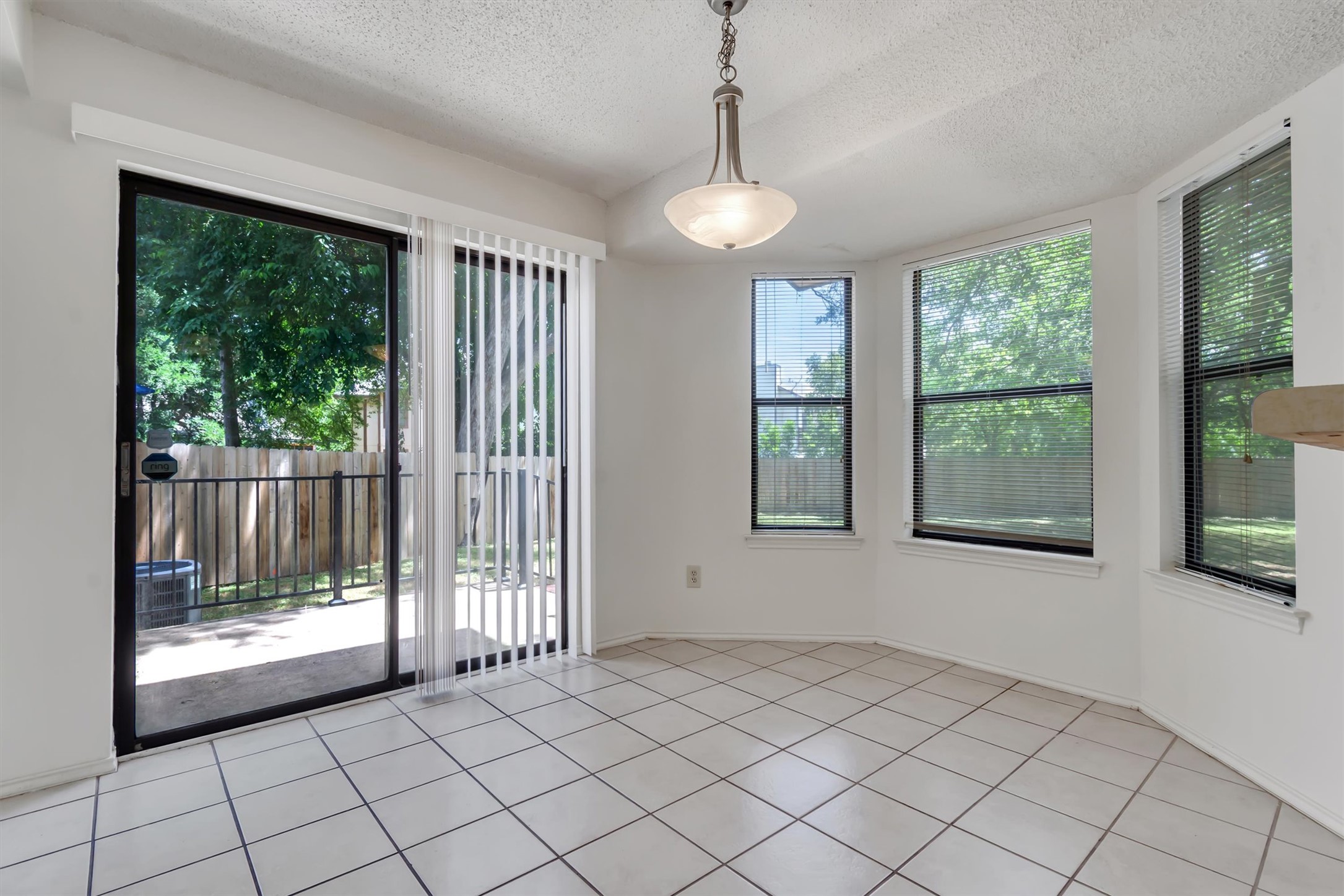 7802 Topawa Cove, Unit B Austin, TX 78729 - Photo 14 of 32 A well-lit dining space offers outdoor access and views of surrounding greenery through generous windows.