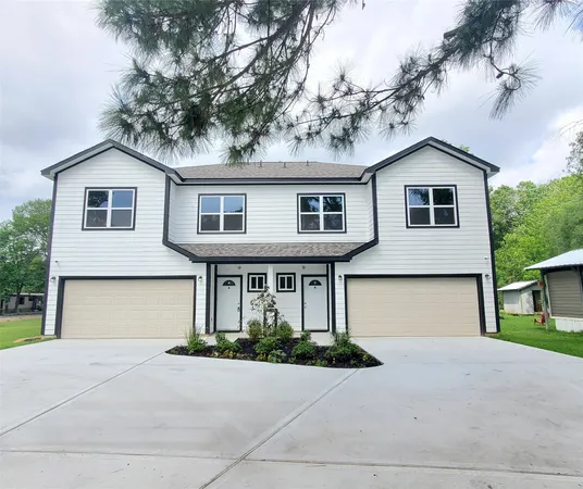 a front view of a house with yard and trees