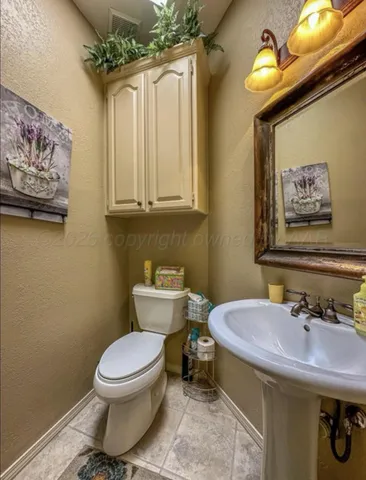 a bedroom with a bed a chair and a chandelier