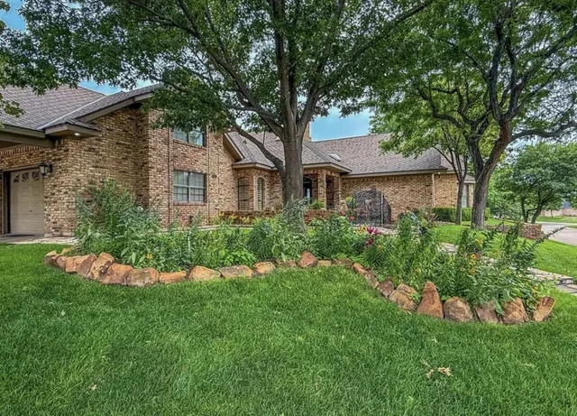 a front view of a house with a yard and trees